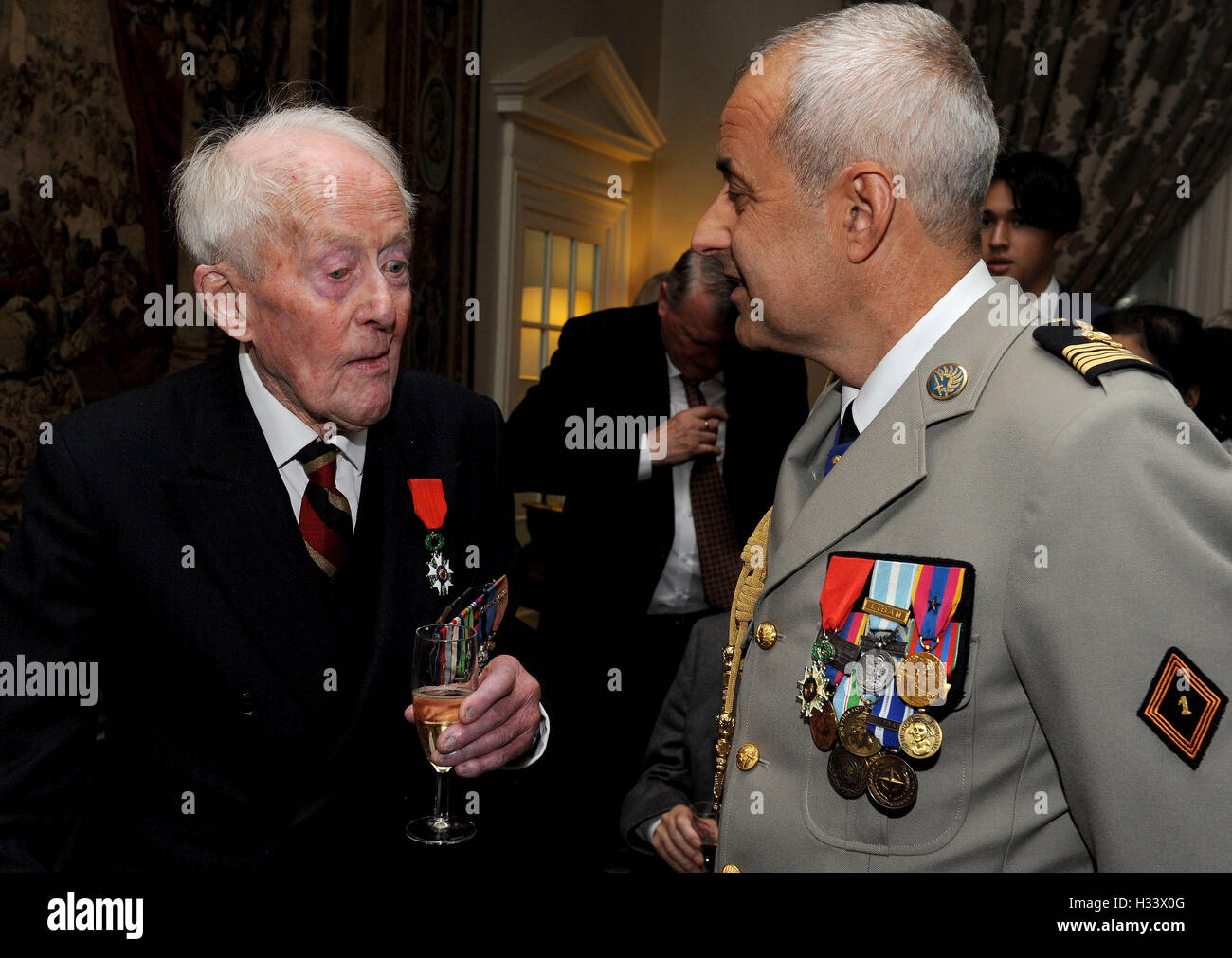 Veteran Humphrey Tottenham, 94, from Wiltshire talks to Colonel De Loustal from the French Parachute Regiment, after he received the Legion d'honneur, France's highest distinction, from the French Ambassador Sylvie Bermann for his role in liberating France during the Second World War, during a ceremony at the Ambassador's residence in Kensington, London. Stock Photo