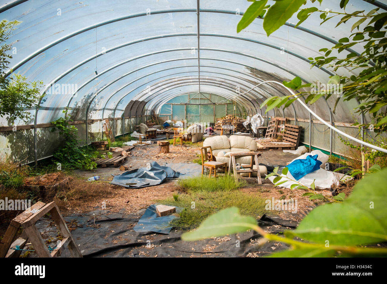 A derelict polytunnel full of debris Stock Photo