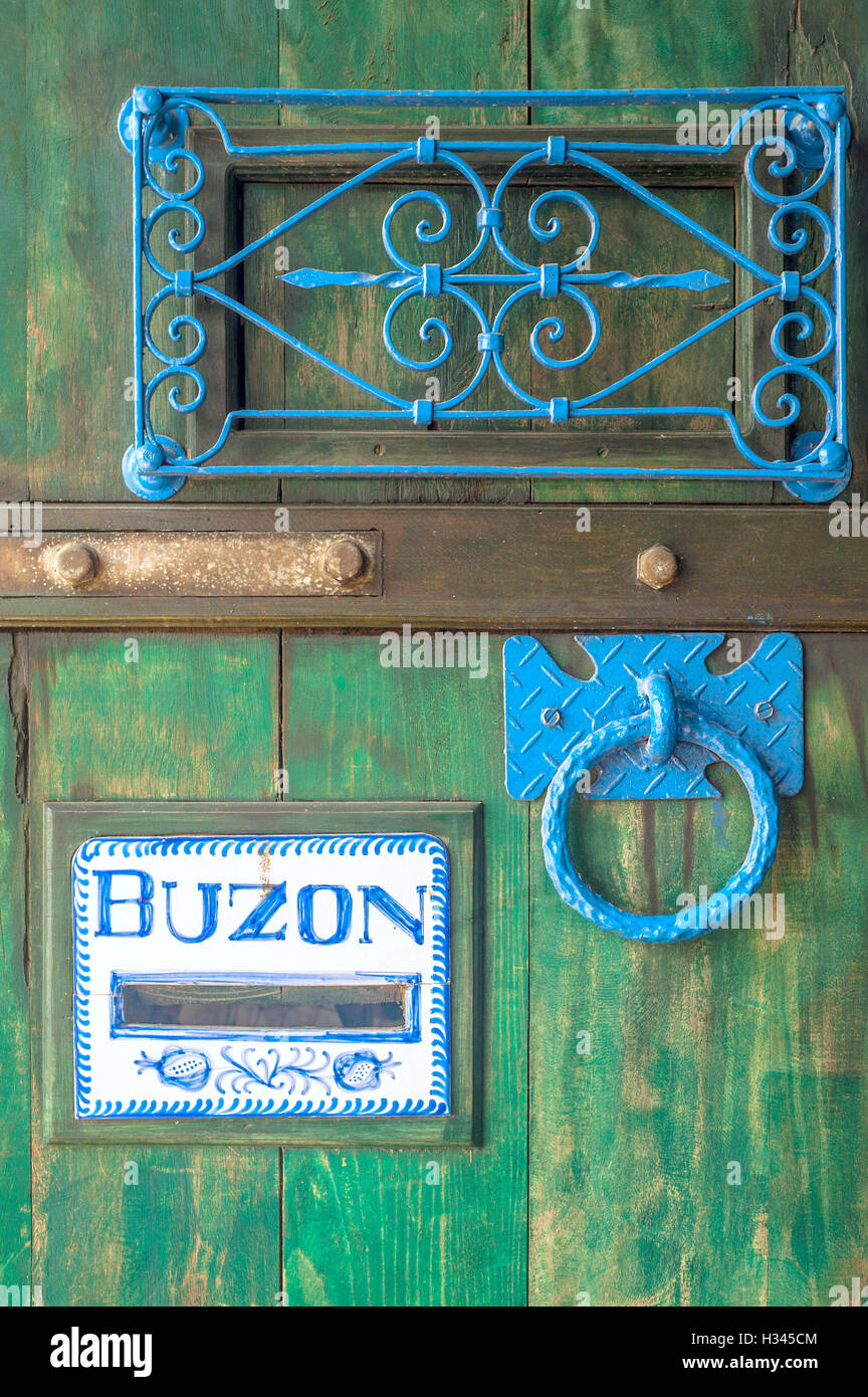 Wooden door with a slot mailbox and the word in Spanish means "box