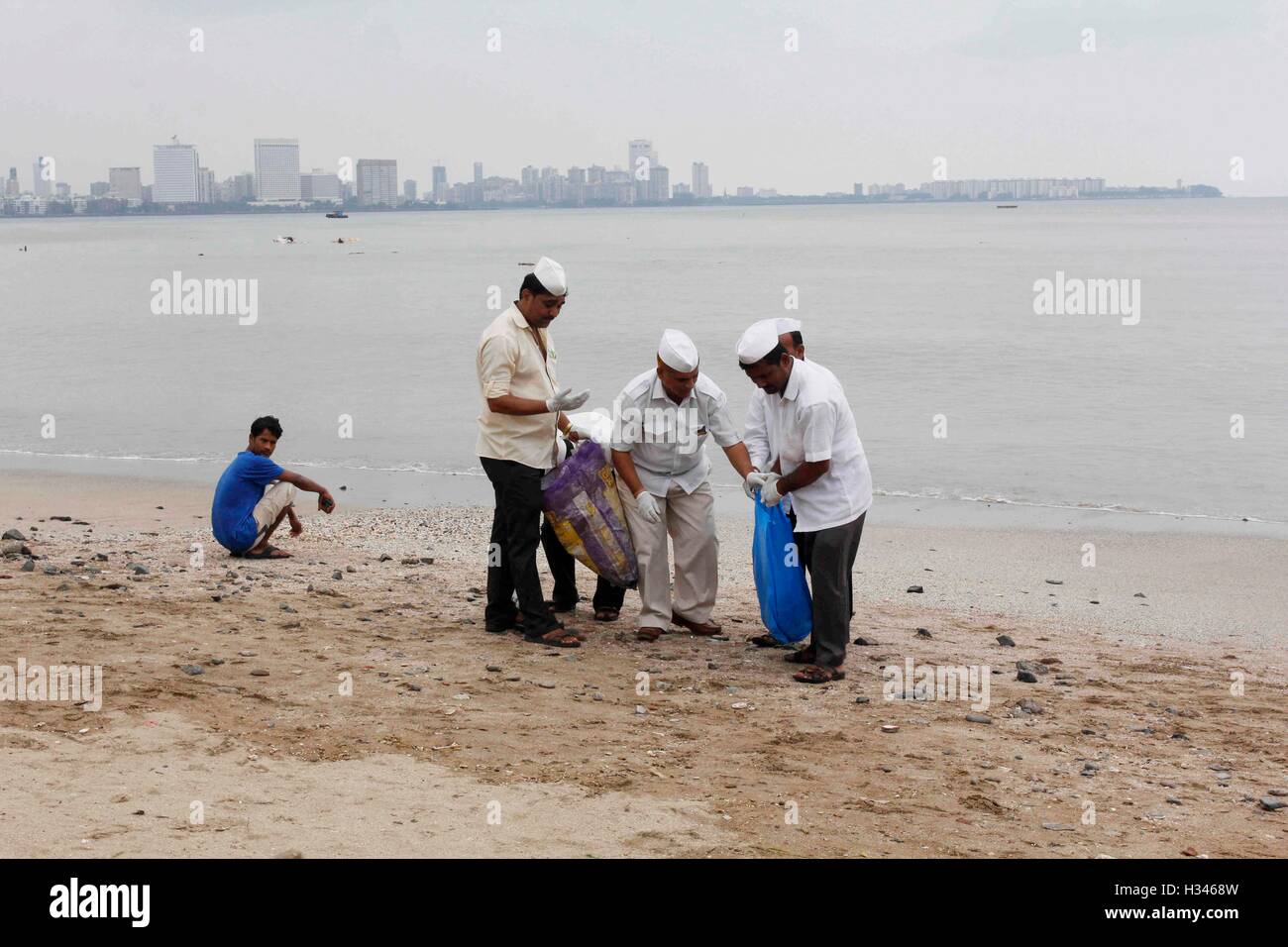 Dabbawalas clean the Chowpatty beach in Mumbai, India on September 16, 2016, and remove the leftover Stock Photo