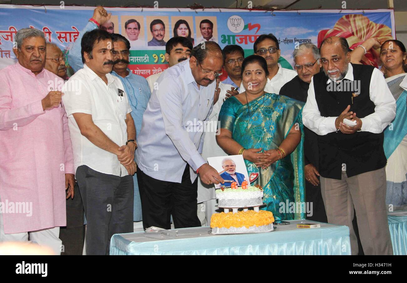 BJP workers cut a cake in Mumbai, India on September 17, 2016, in celebration of Prime Minister Narendra Modi's birthday Stock Photo