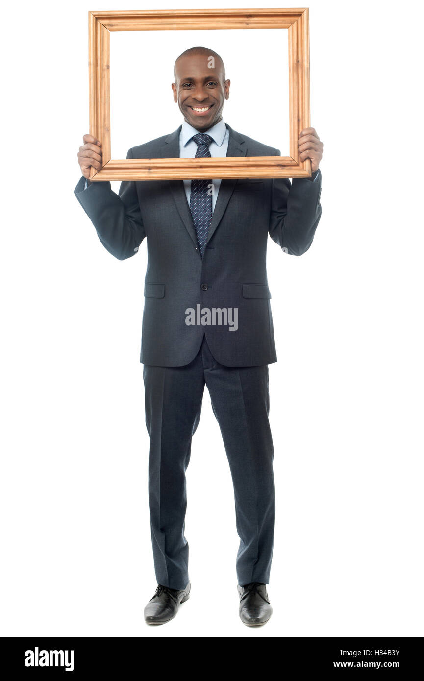 Smiling guy looking through picture frame Stock Photo Alamy