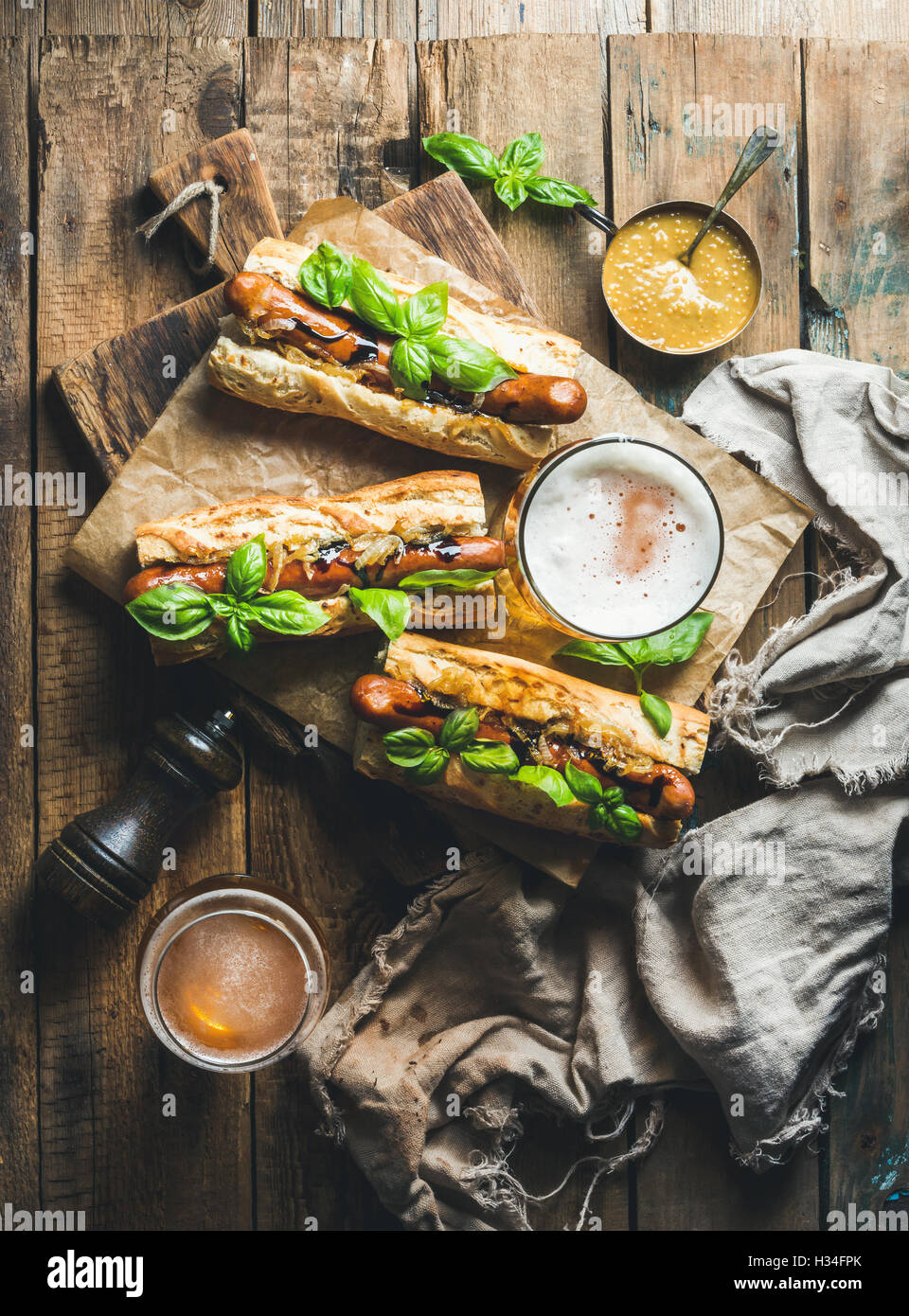 Wheat unfiltered beer and grilled sausage dogs in baguette Stock Photo