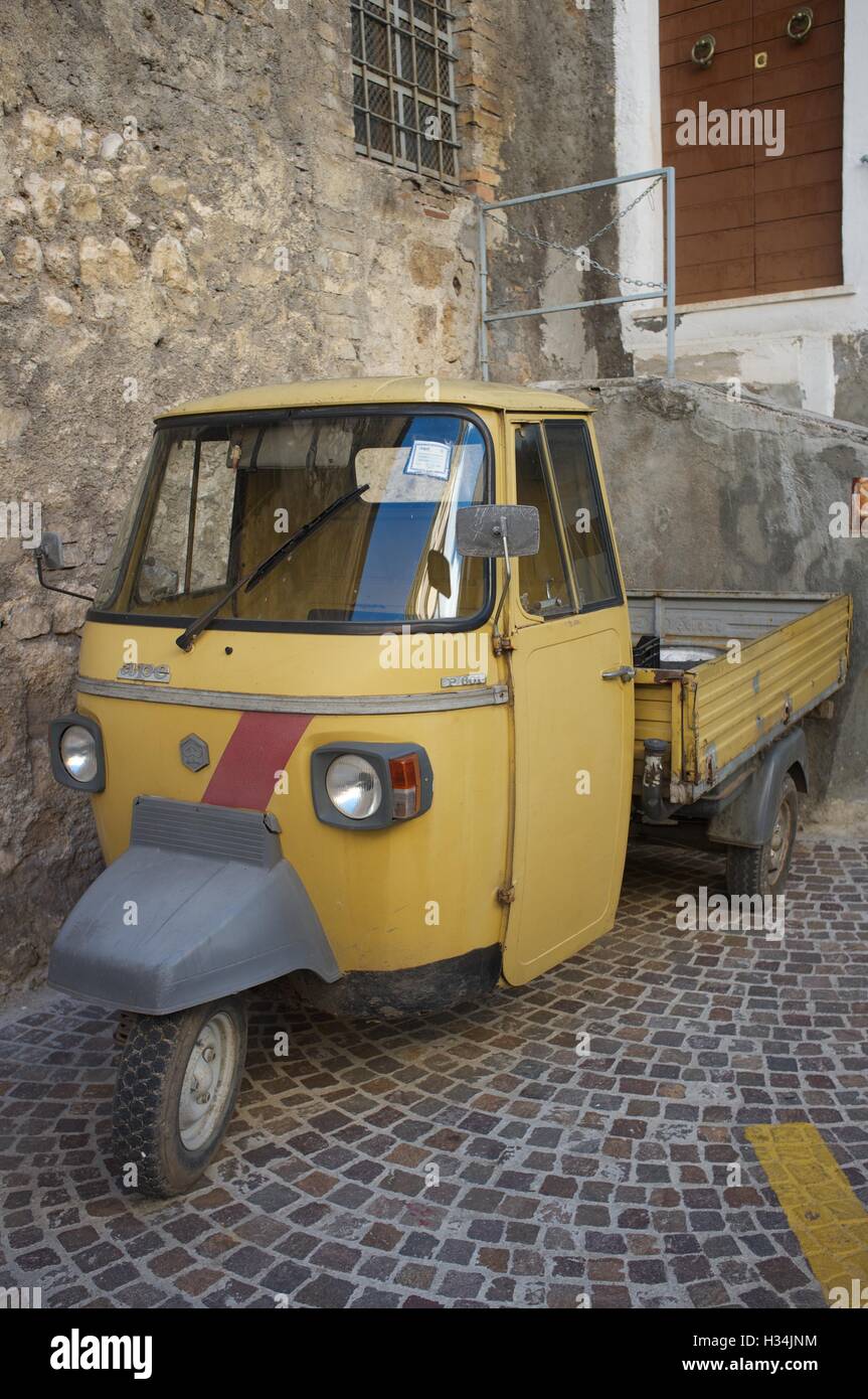 Piaggio ape open backed van parked it Italian piazza Stock Photo