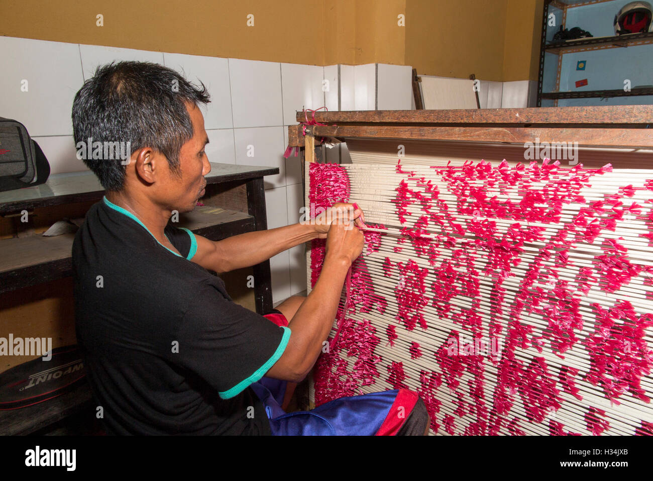 Indonesia, Bali, Singaraja, Pertenunan Berdikari weaving worker hand tying dye resist