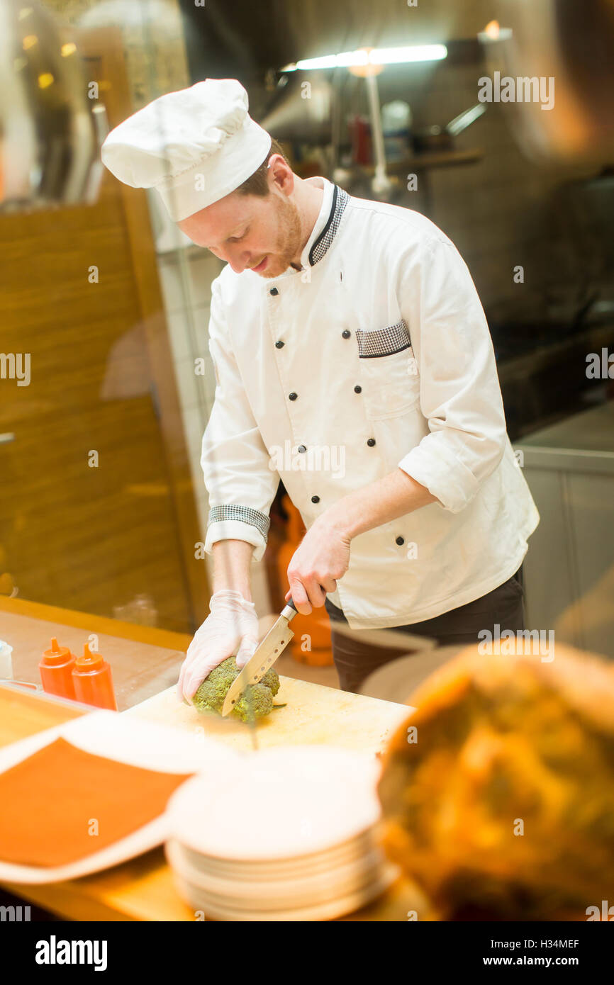 Chef preparing food in the kitchen at the restaurant Stock Photo