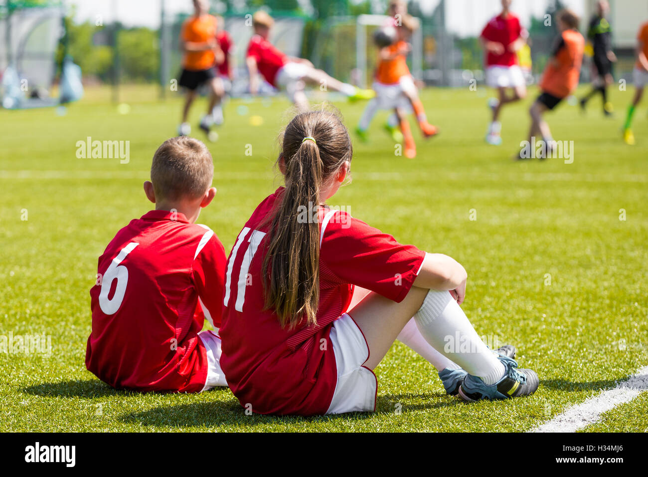 Children soccer players playing game. Young girl and boy soccer players
