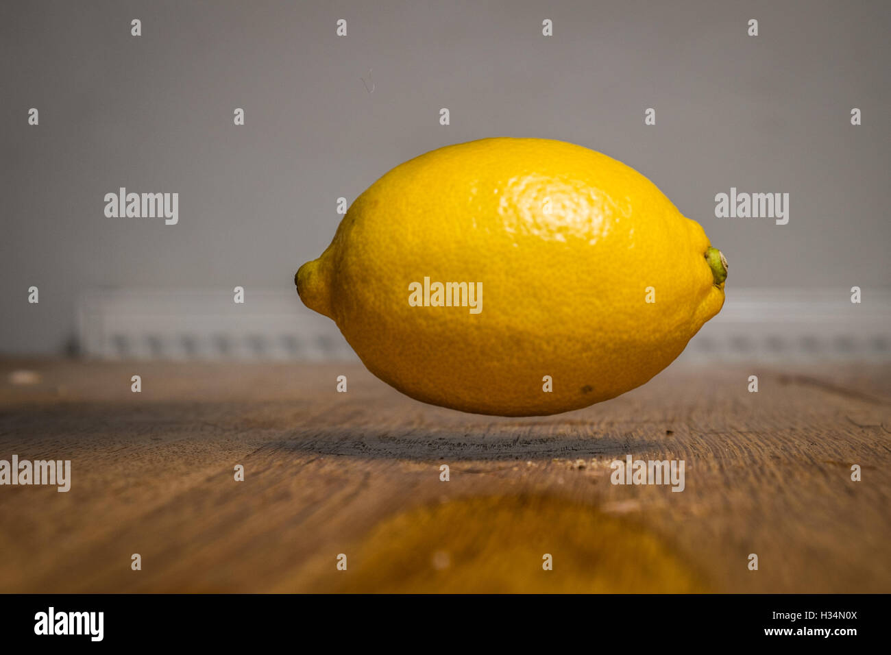 A lemon floating just above a table Stock Photo
