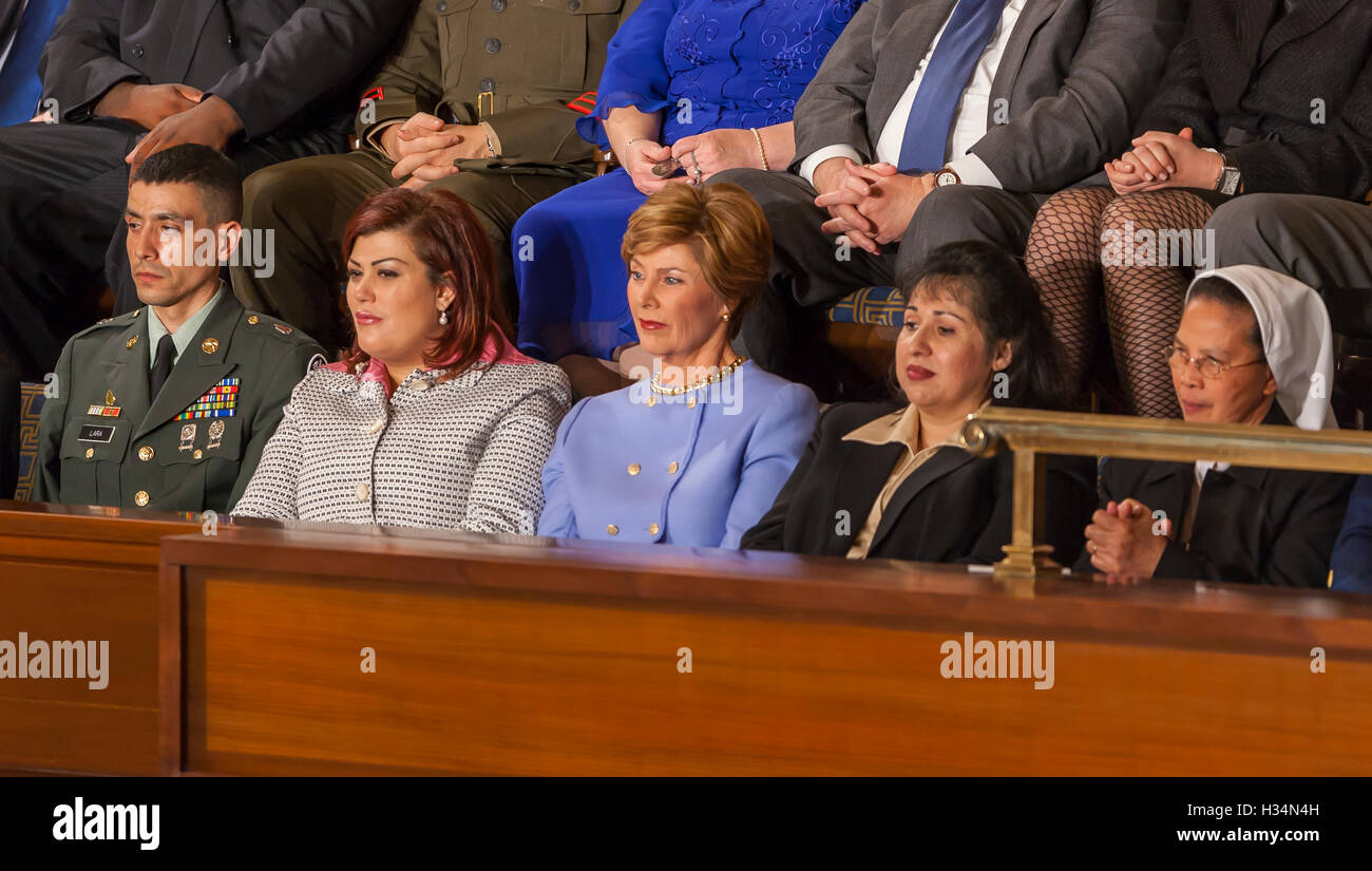 WASHINGTON, DC, USA - First Lady Laura Bush, center, listens to her husband President George W. Bush delivering his State of the Union speech before Congress on February 2, 2005. On either side of Mrs. Bush are two women from Afghanistan and Iraq who voted in their countries' democratic elections. Stock Photo