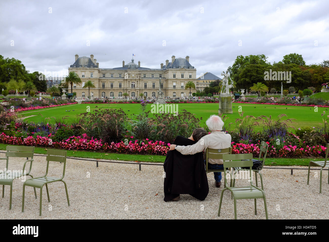A couple embrace while enjoying the view of the Luxembourg Palace in Luxembourg Gardens in Paris, France. Stock Photo