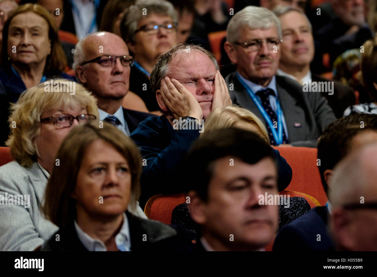 Conservative Party Conference day 3 on 04/10/2016 at Birmingham ICC, Birmingham. Pictured: A delegate rests his head in his hands as he concentrates on a speech   . Picture by Julie Edwards. Stock Photo