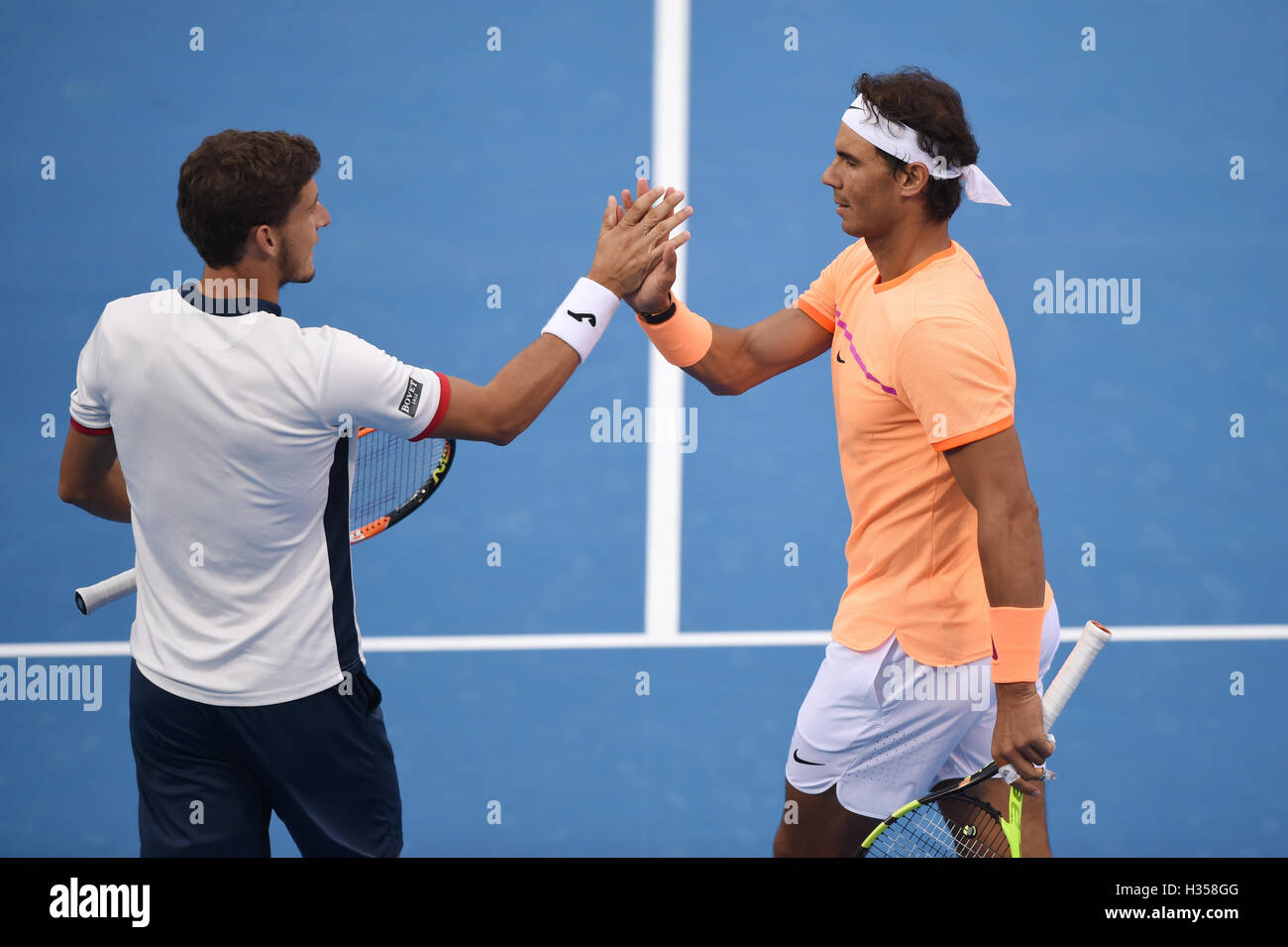 Beijing, China. 5th Oct, 2016. Rafael Nadal (R) of Spain celebrates the victory with his partner Pablo Carreno Busta of Spain after winning the men's quarterfinal against Gong Maoxin and Zhang Ze of China at the China Open tennis tournament in Beijing, capital of China, Oct. 5, 2016. The Spanish pair won 2-0. Credit:  Ju Huanzong/Xinhua/Alamy Live News Stock Photo