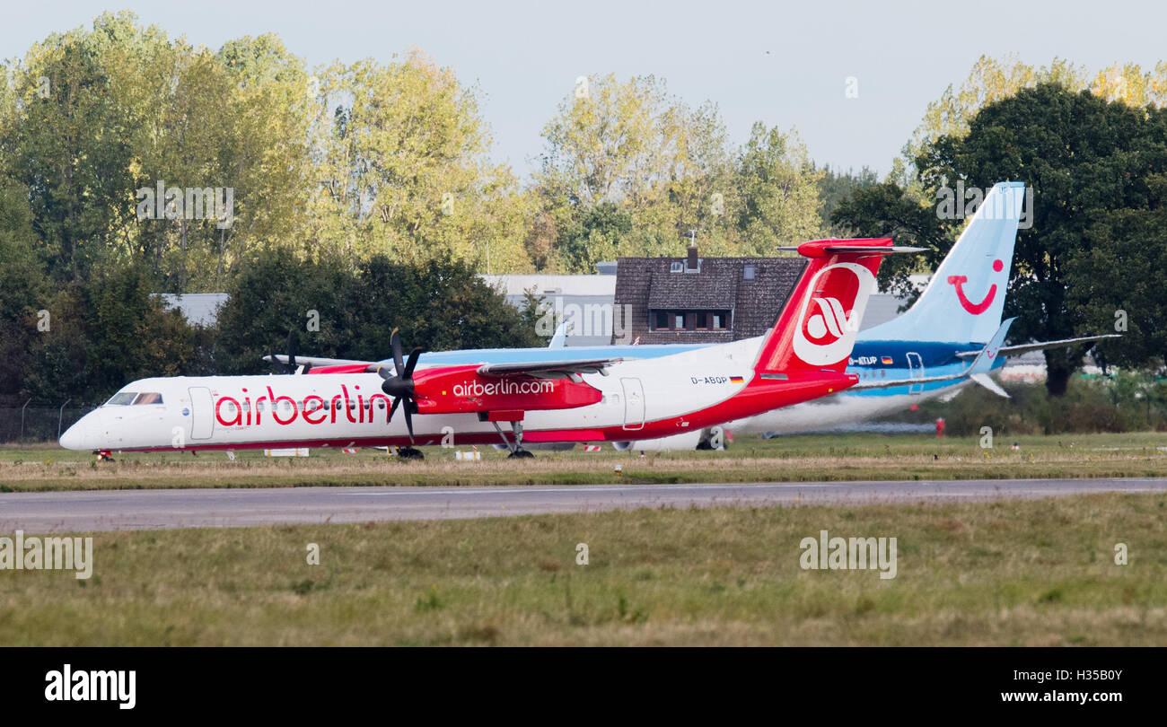 An Air Berlin Bombardier and a Tuifly Boeing 737-800 seen on the runway of the airport in Hanover, Germany, 05 October 2016.  Airline company Etihad and tourism company Tui announced that they plan on merging parts of Air Berlin and Tuifly into a new venture offering holiday flights. Photo: JULIAN STRATENSCHULTE/dpa Stock Photo