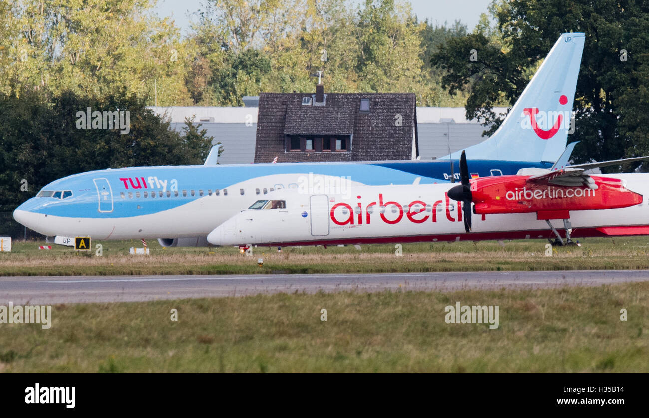 An Air Berlin Bombardier and a Tuifly Boeing 737-800 seen on the runway of the airport in Hanover, Germany, 05 October 2016.  Airline company Etihad and tourism company Tui announced that they plan on merging parts of Air Berlin and Tuifly into a new venture offering holiday flights. Photo: JULIAN STRATENSCHULTE/dpa Stock Photo