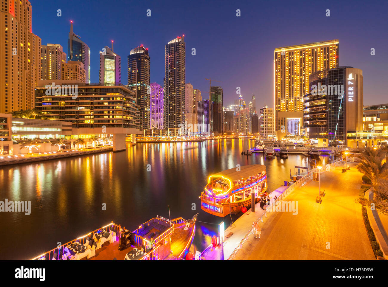 Dubai Marina skyline and tourist boats at night, Dubai City, United Arab Emirates, Middle East Stock Photo