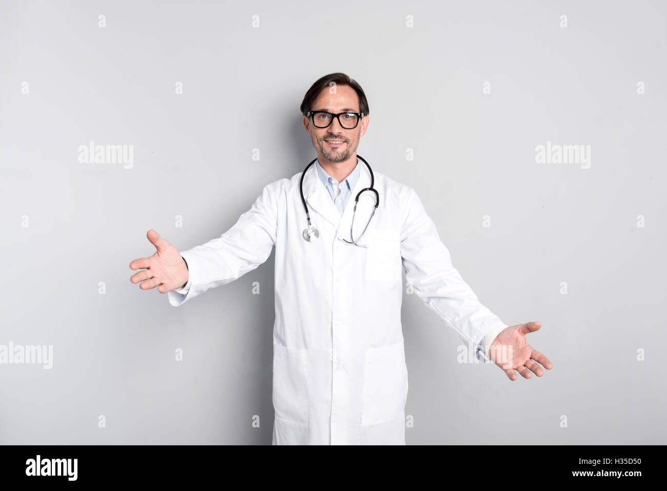 Friendly doctor making an inviting gesture Stock Photo