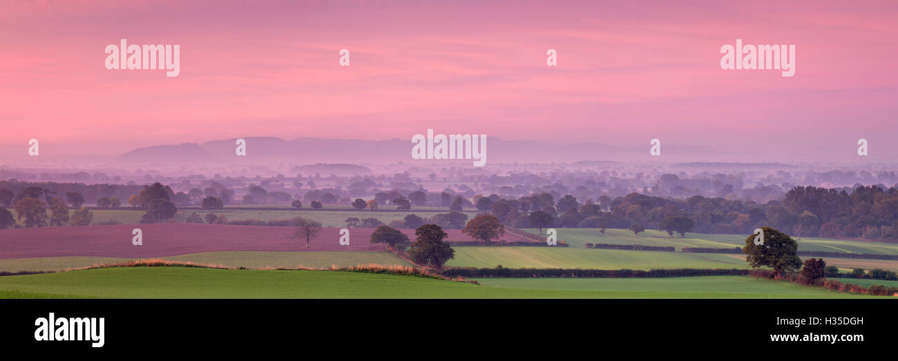 Autumn dawn across the Cheshire plain with Beeston Castle and the Peckforton Hills receding into the morning mist, Cheshire, UK Stock Photo