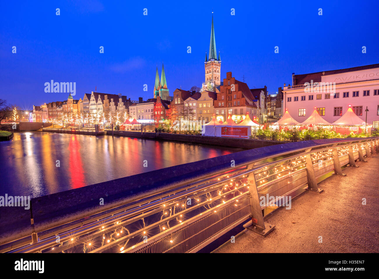 Night view of typical houses and the cathedral reflected in River Trave, Lubeck, Schleswig Holstein, Germany Stock Photo