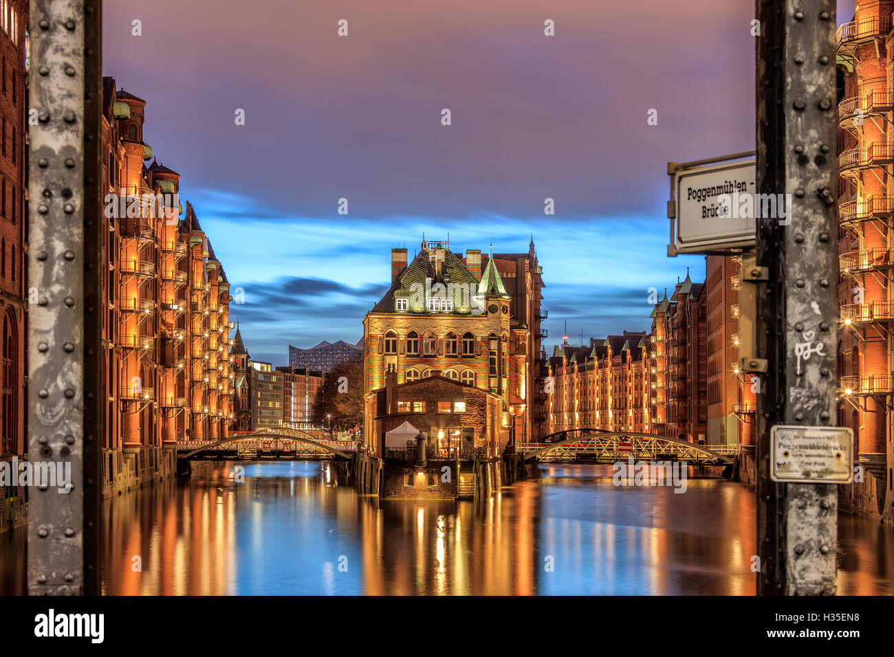 Blue dusk and lights are reflected in Poggenmohlenbrucke with water castle between bridges, Altstadt, Hamburg, Germany Stock Photo