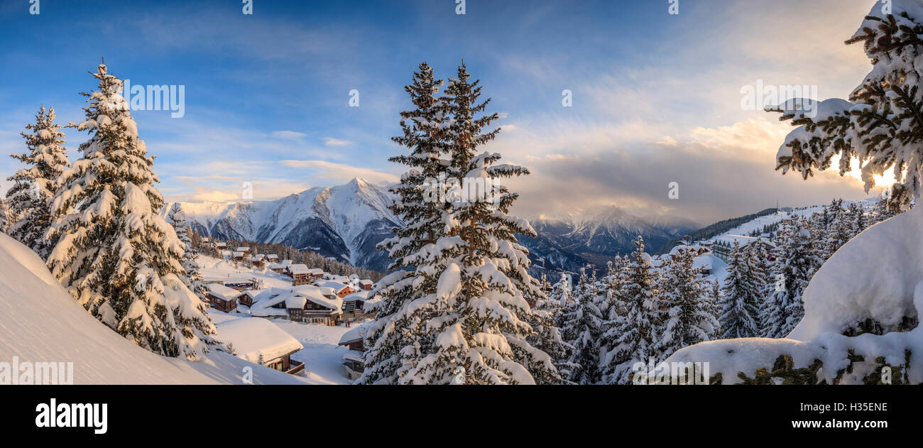 Panorama of snowy woods and mountain huts framed by sunset, Bettmeralp, district of Raron, canton of Valais, Switzerland Stock Photo