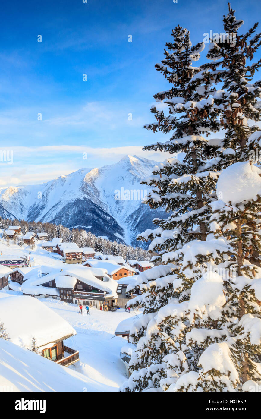 Snowy woods and mountain huts framed by the winter sunset, Bettmeralp, district of Raron, canton of Valais, Switzerland Stock Photo