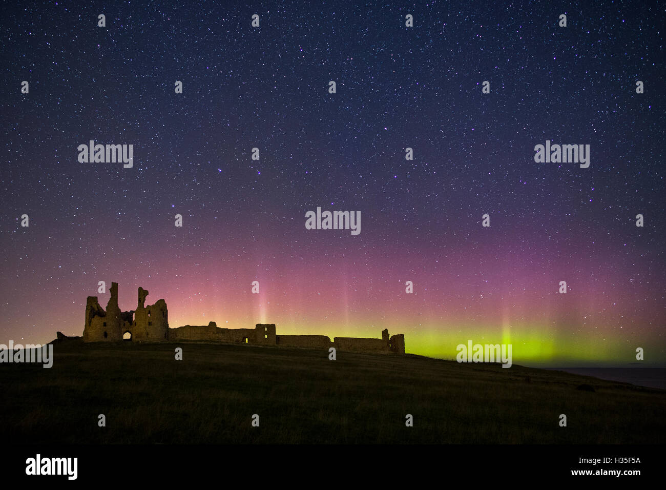 The Northern Lights at Dunstanburgh Castle, Northumberland Stock Photo