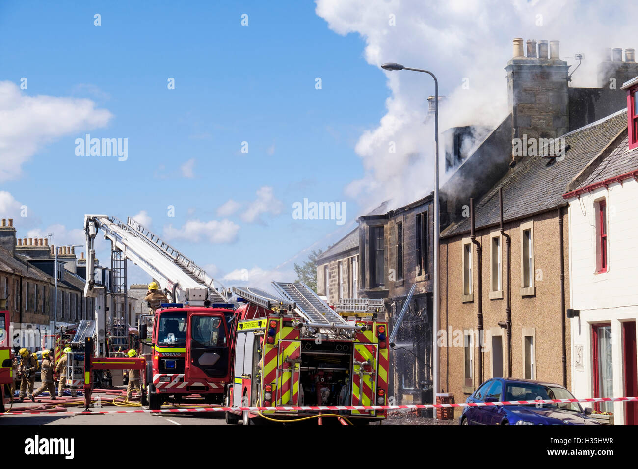 Scottish Fire and Rescue Service firefighters attending a burnt out shop and house. Elie and Earlsferry Fife Scotland UK Britain Stock Photo