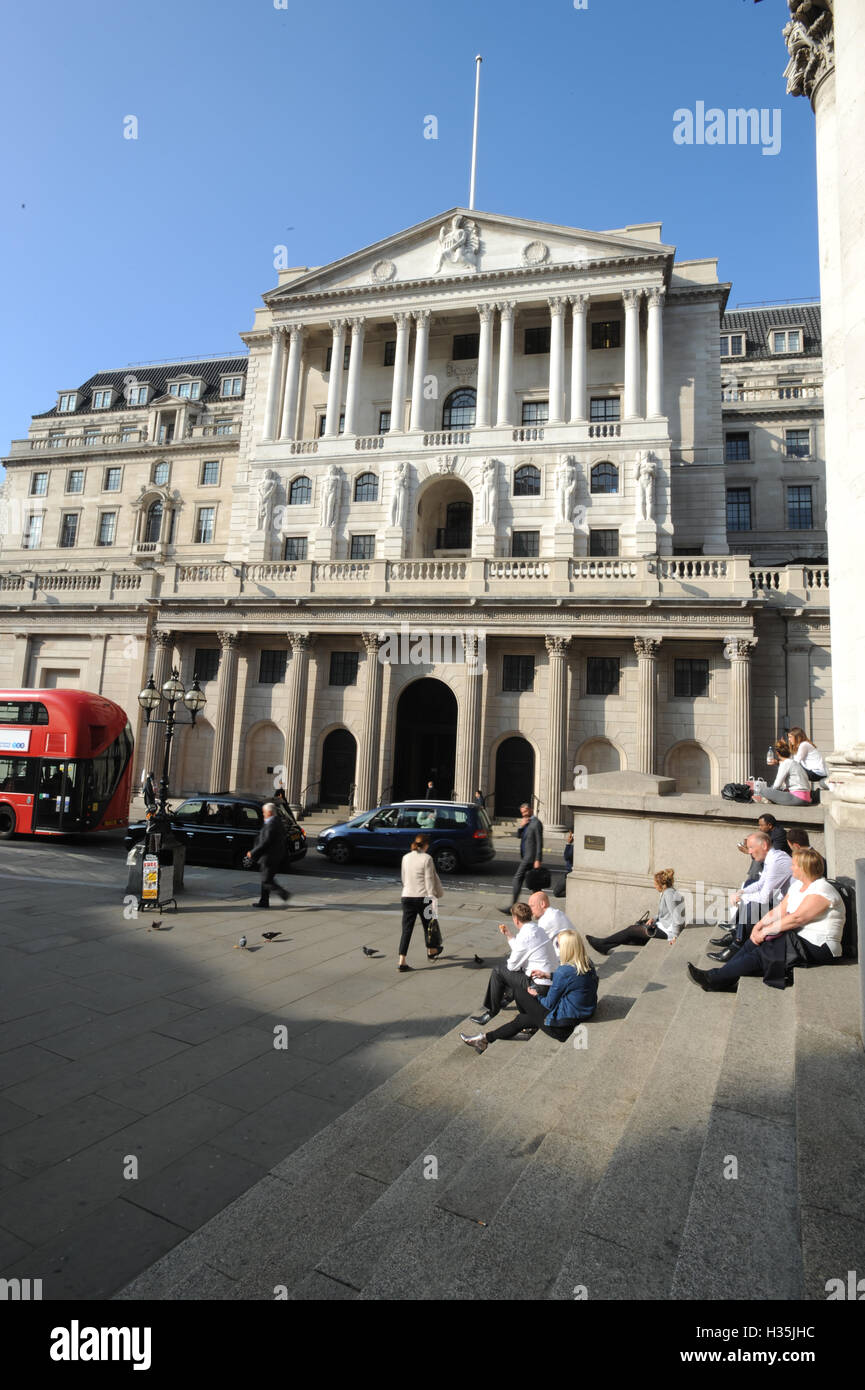 Office workers sit in the sun on the steps of the Royal Exchange opposite the Bank of England in the City of London, as worries over Brexit negotiations have sent the pound tumbling to fresh 31-year lows, but the London market has powered ahead as sterling's woes have buoyed stocks. Stock Photo