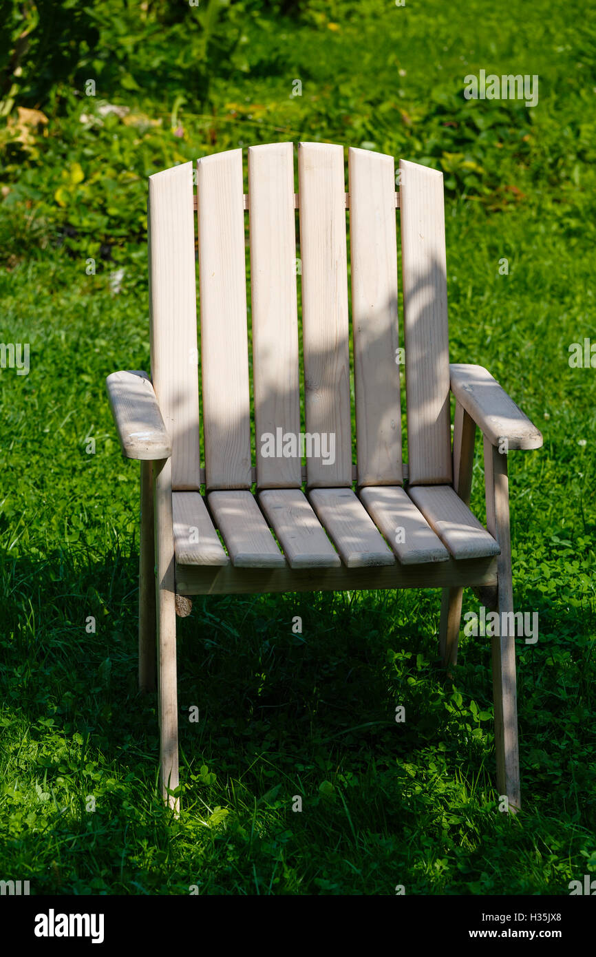Wooden chair from a set of garden furniture on a green lawn Stock Photo