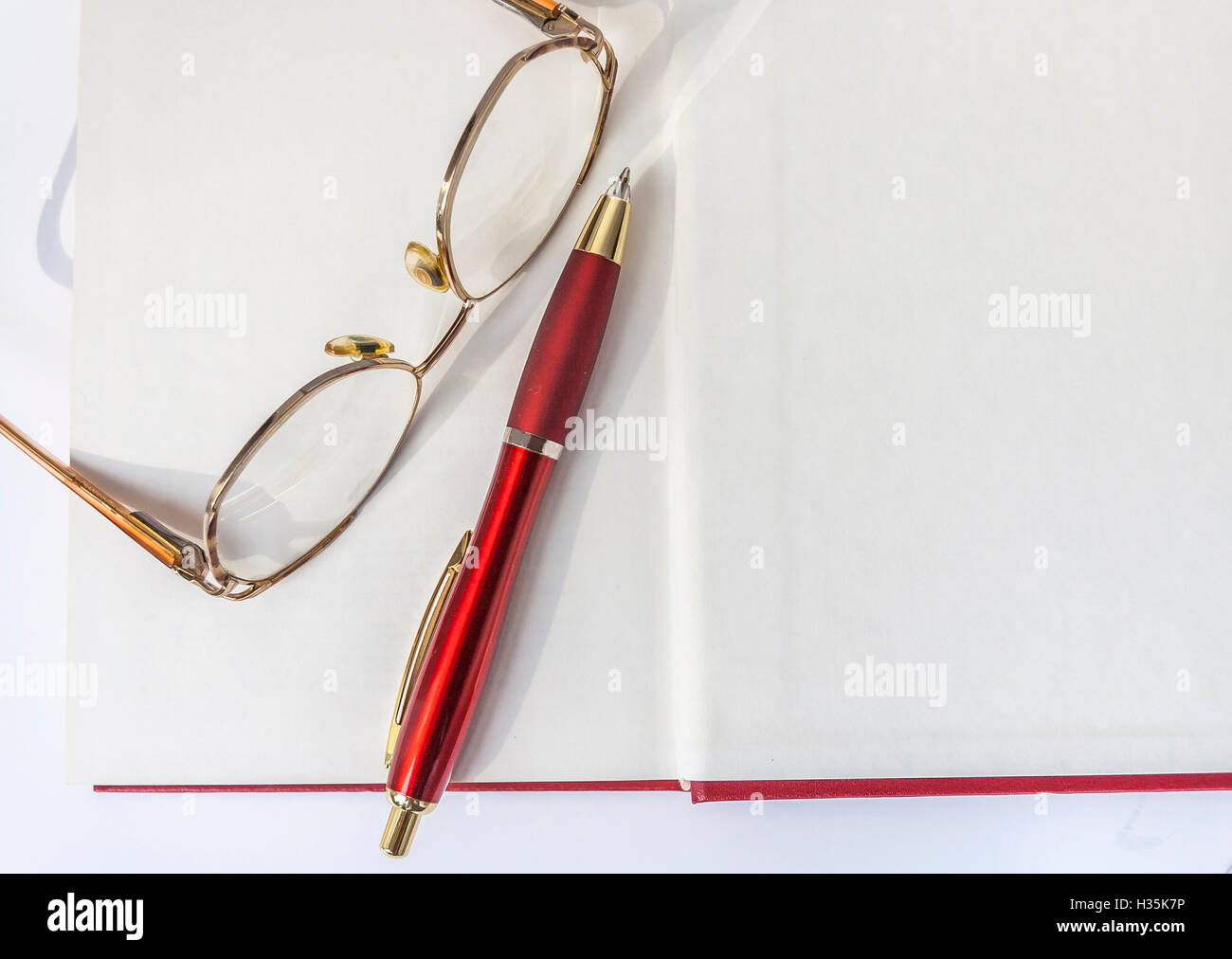 Reading Glasses And Ballpoint Pen Lying On The Open Book Stock Photo ...