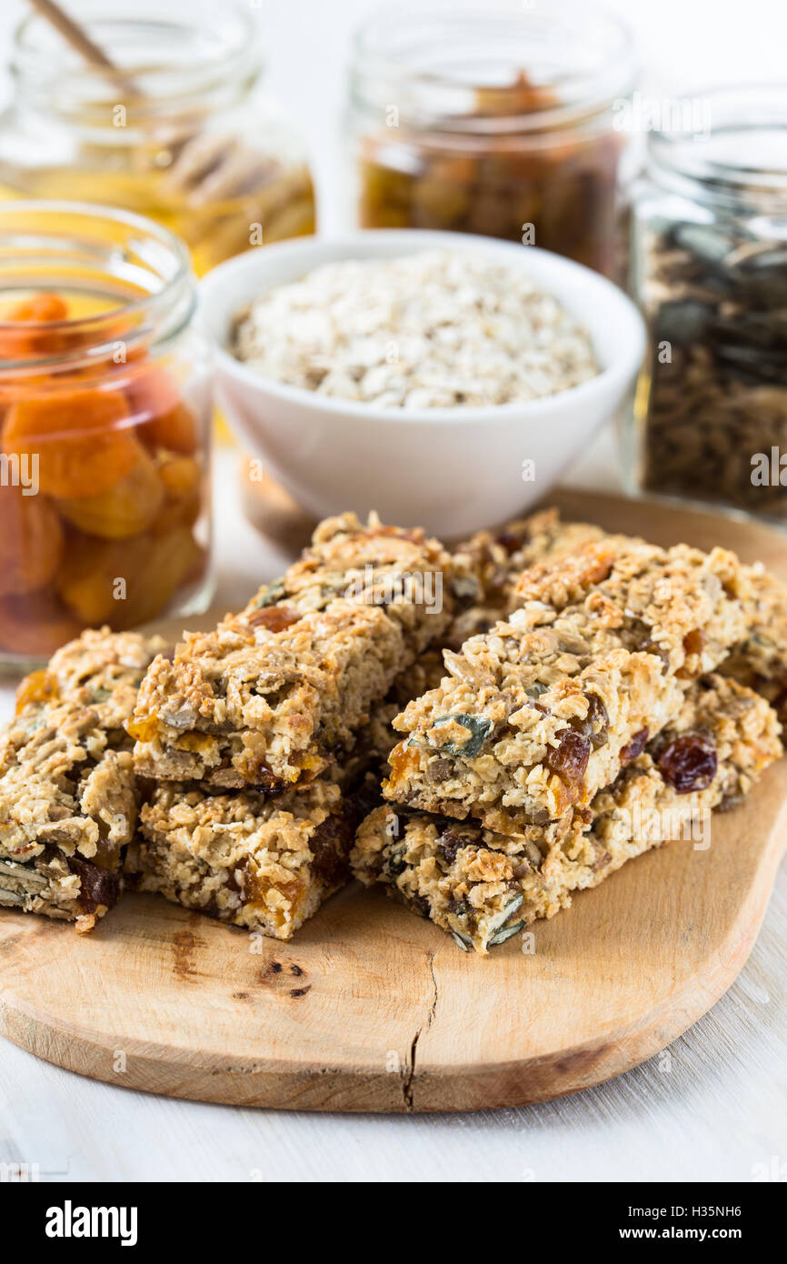 Healthy homemade granola bars and various ingredients on background