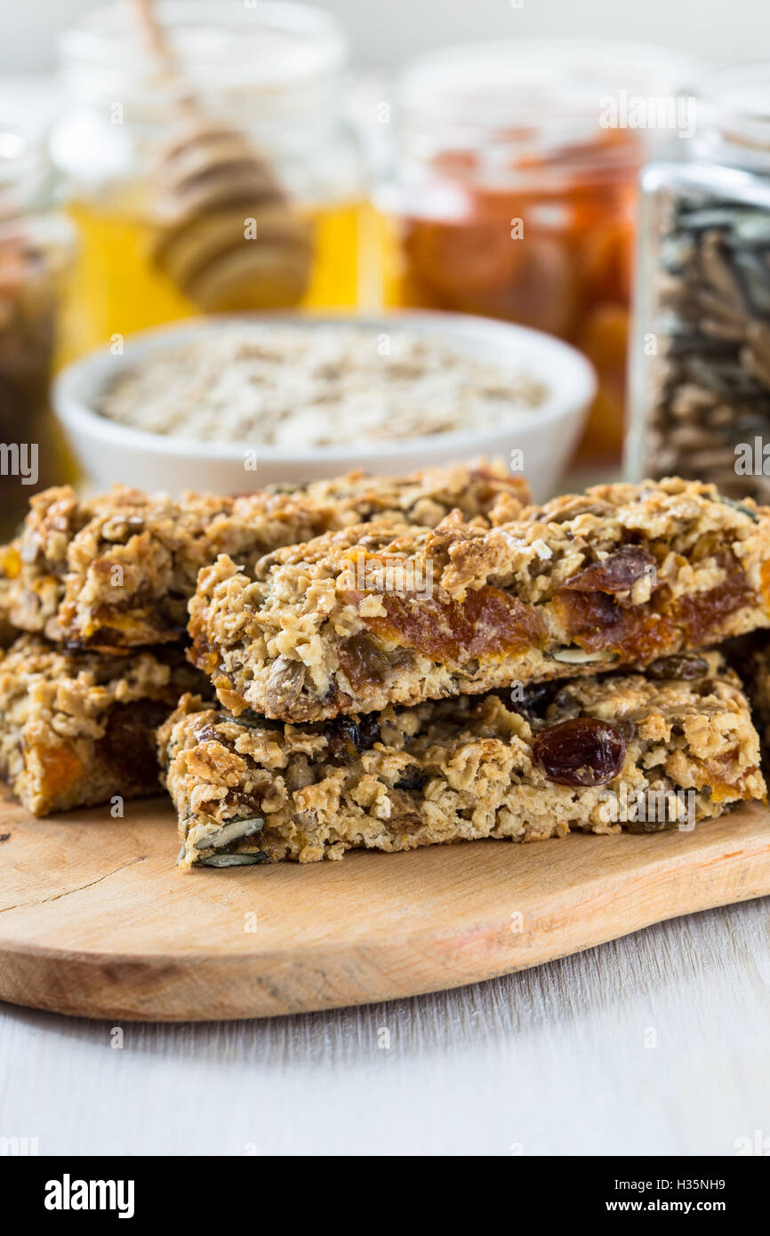 Healthy homemade granola bars and various ingredients on background