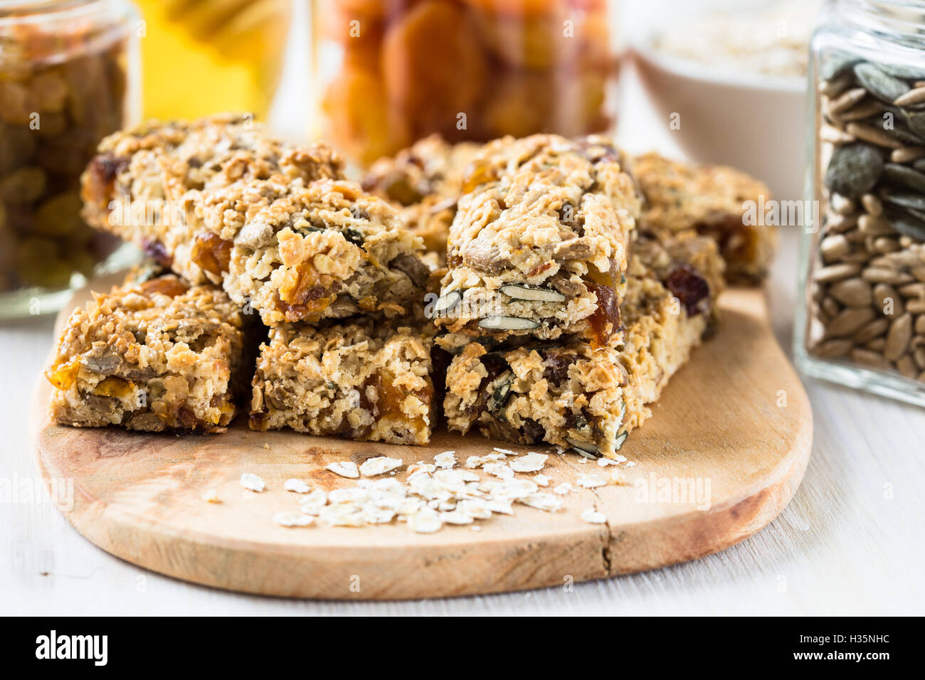 Healthy homemade granola bars and various ingredients on background
