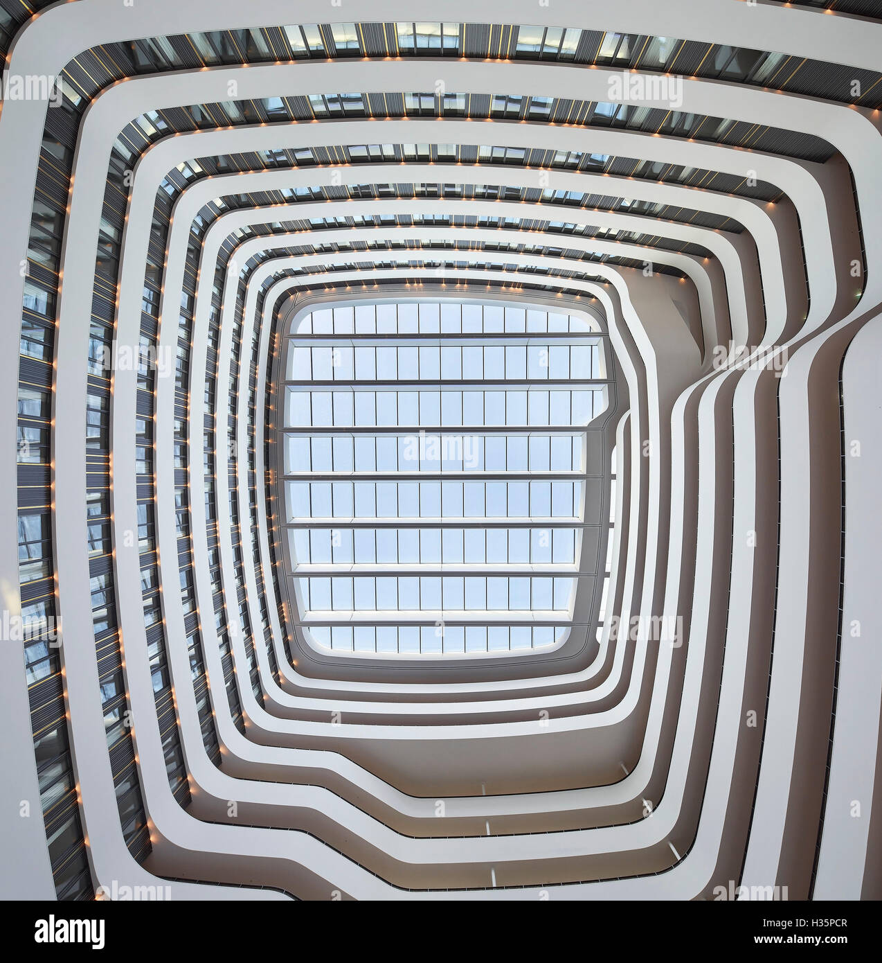 View towards atrium's glass ceiling. Hilton Amsterdam Airport Schiphol, Amsterdam, Netherlands. Architect: Mecanoo Architects, 2015. Stock Photo