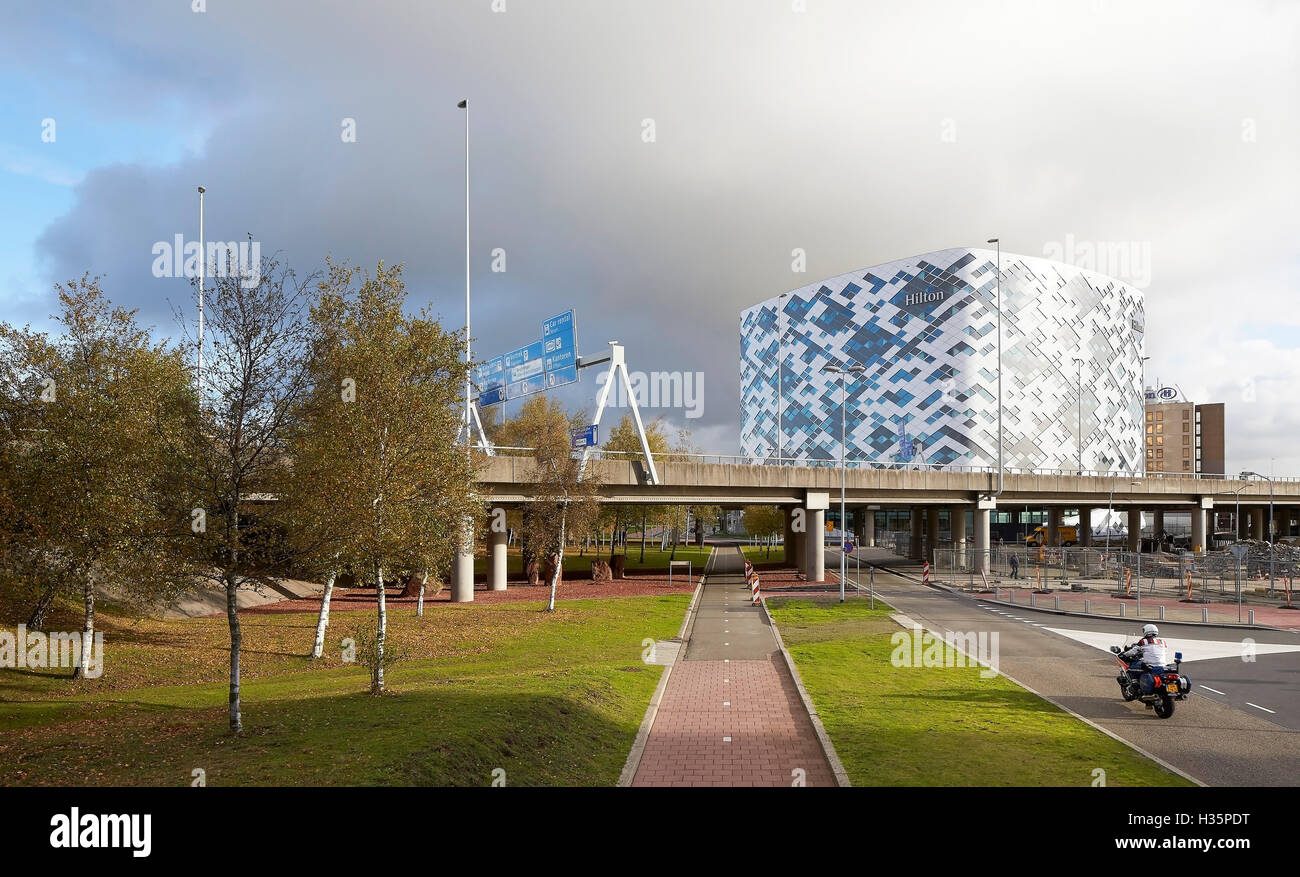 Building elevation in morning light. Hilton Amsterdam Airport Schiphol, Amsterdam, Netherlands. Architect: Mecanoo Architects, 2015. Stock Photo