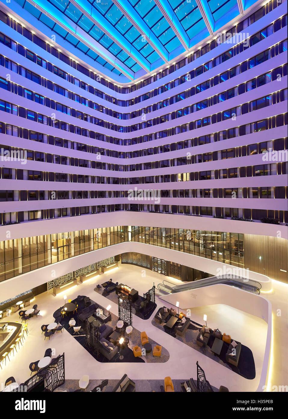 Atrium with mood lighting. Hilton Amsterdam Airport Schiphol, Amsterdam, Netherlands. Architect: Mecanoo Architects, 2015. Stock Photo