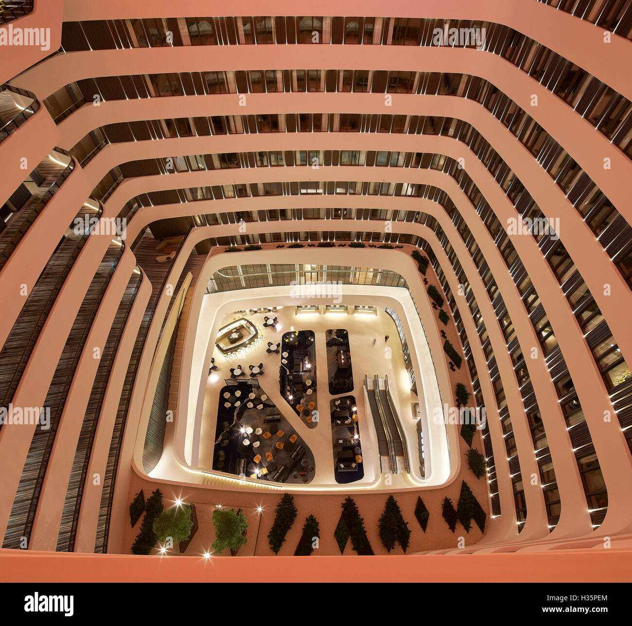 Illuminated foyer on ground floor viewed from above. Hilton Amsterdam Airport Schiphol, Amsterdam, Netherlands. Architect: Mecanoo Architects, 2015. Stock Photo