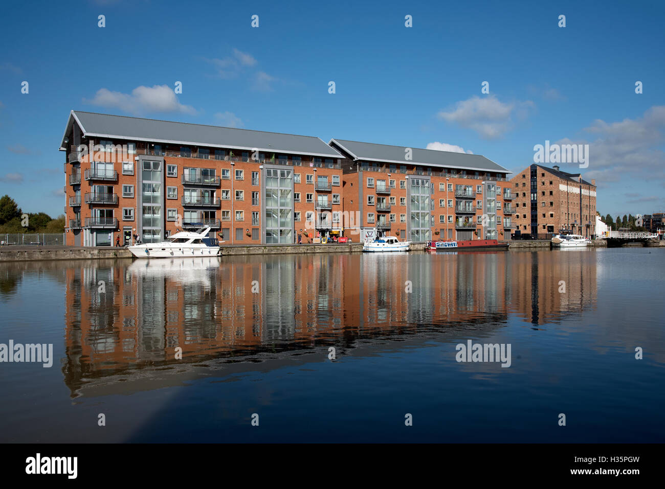 England UK  New build apartment blocks sitting waterside on the main basin of Gloucester Docks Stock Photo