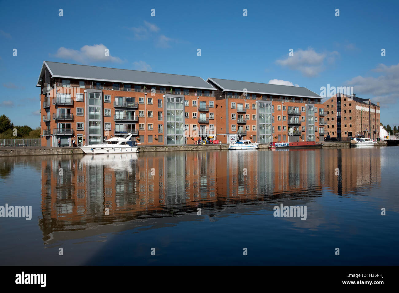 England UK  New build apartment blocks sitting waterside on the main basin of Gloucester Docks Stock Photo