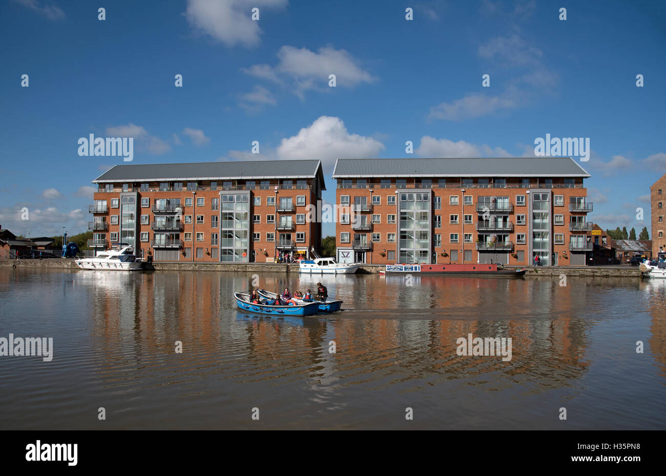 England UK  New build apartment blocks sitting waterside on the main basin of Gloucester Docks Stock Photo