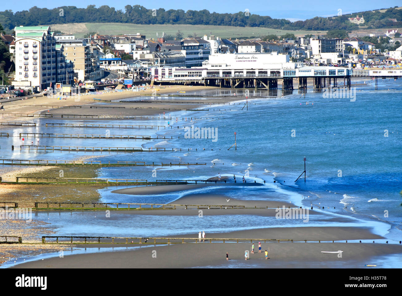View from above British seaside beach holiday resort Sandown Pier Isle of Wight low tide sea breakwaters & groins England uk on blue sky day summer Stock Photo