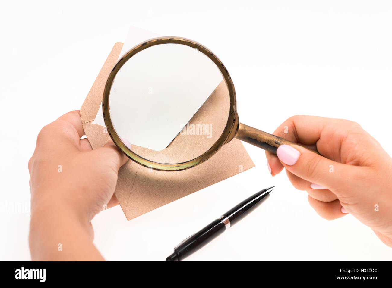 The female hands with envelope with magnifying glass on white background Stock Photo