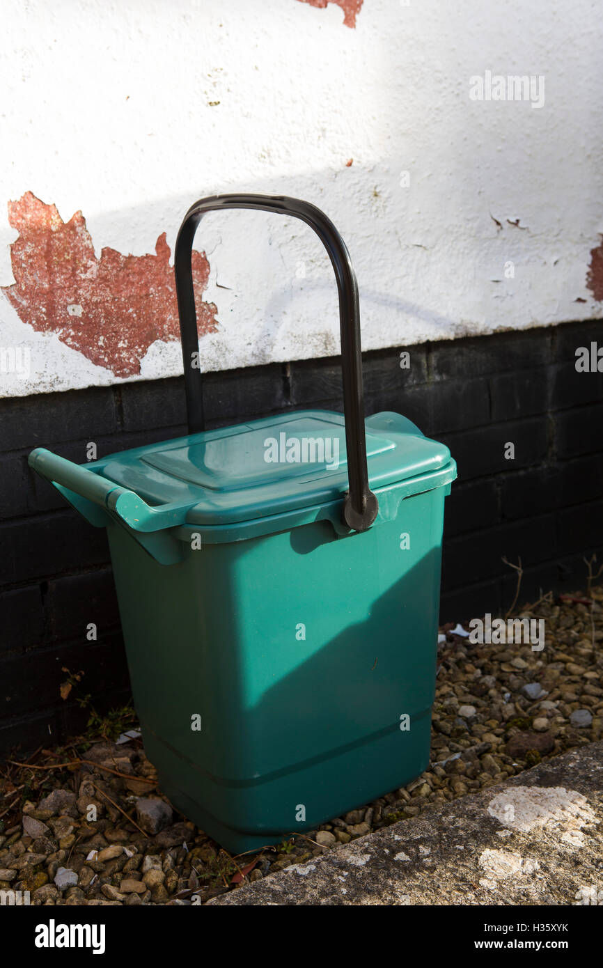 Green plastic recycling container outside a house. Stock Photo