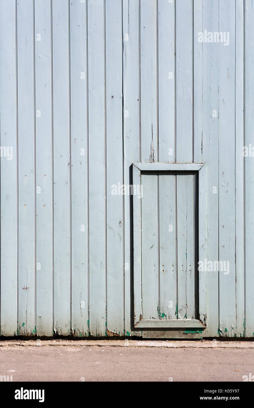 Small access door set into a larger gated wall Stock Photo Alamy