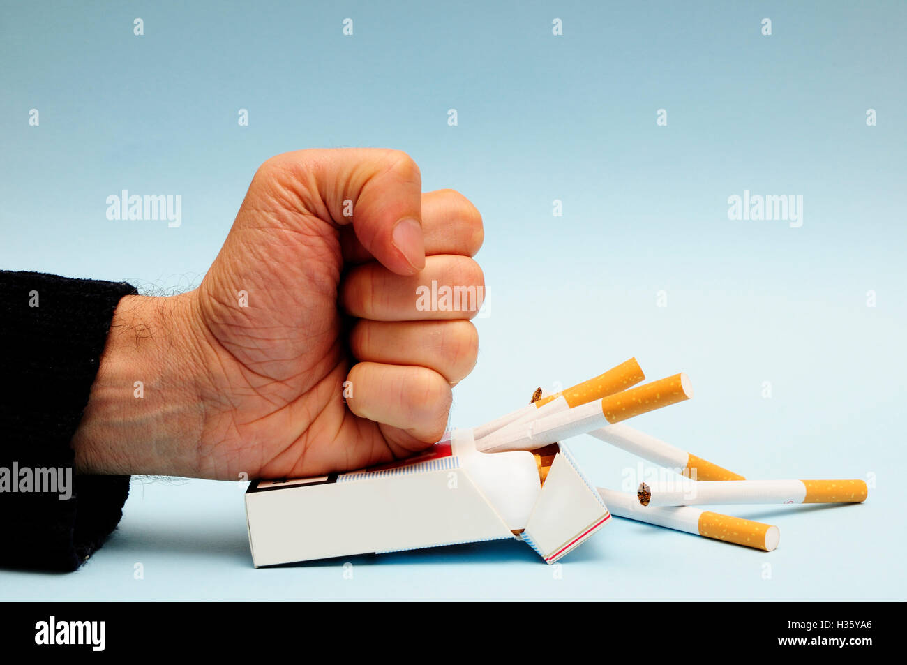 hand smashing a pack of cigarettes, Unsmoke campaign for quitting smoking Stock Photo