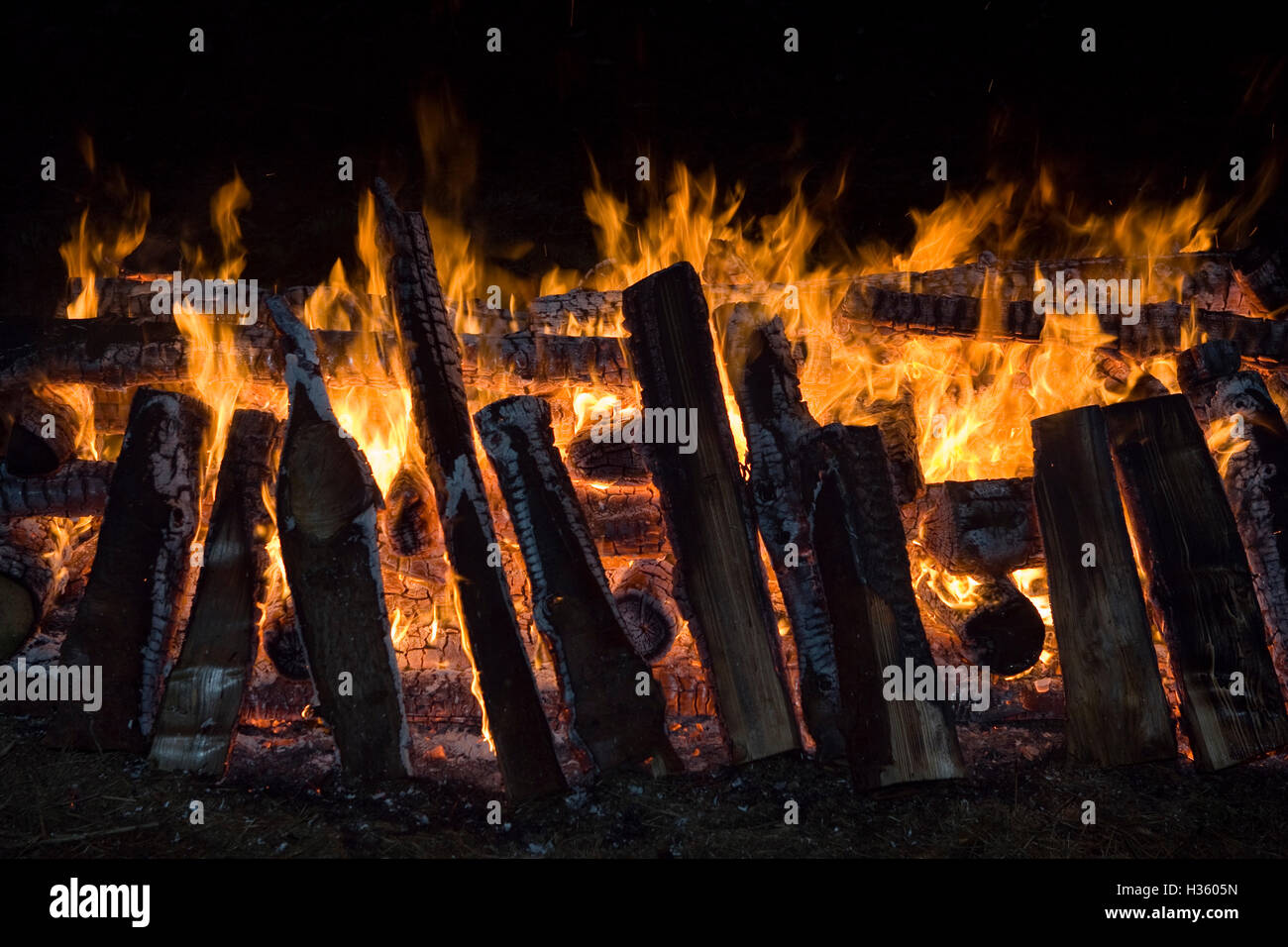 Logs, wood burning on what could be described as a funeral pyre in some