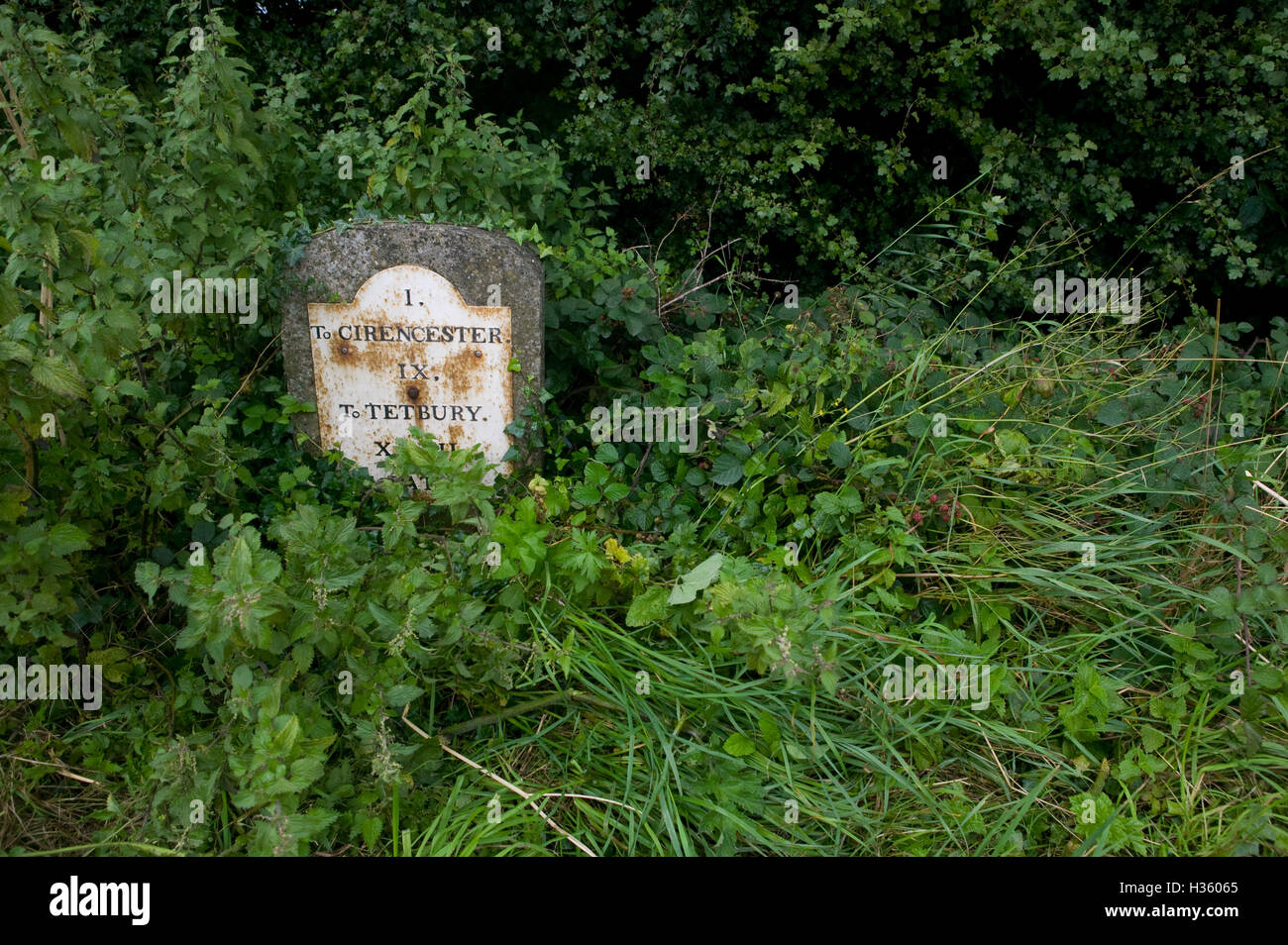 An old mile marker or stone used on road sides to indicate distances to towns and villages. Stock Photo
