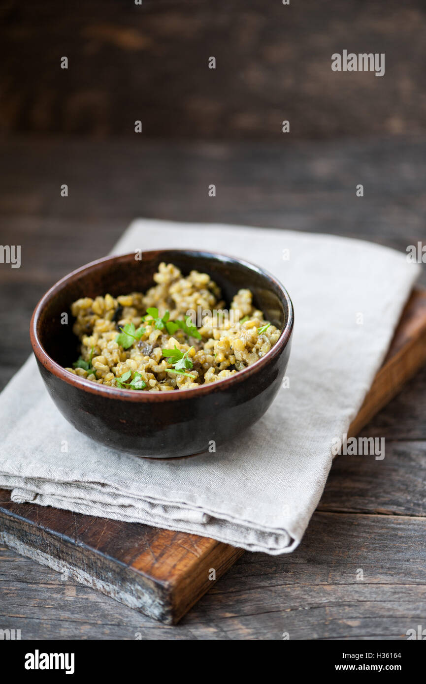 Mushroom risotto with brown rice, parsley and turmeric Stock Photo