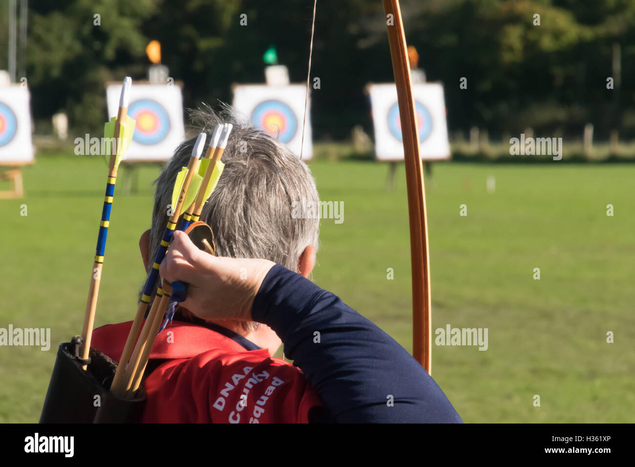 Archer retrieving arrow from back quiver at archery competition Stock Photo