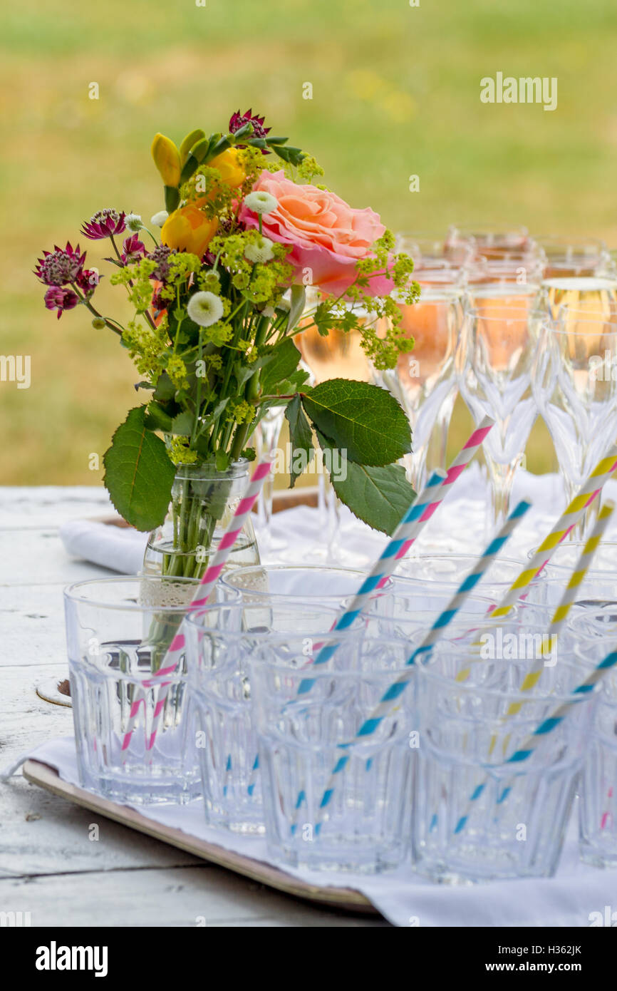 pretty small bouquet of flowers and tumblers ready for garden party Stock Photo